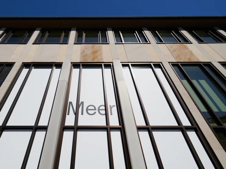 Fassade der Kunstgalerie mit vertikalen Fenstern und dem Schriftzug 'Meer'