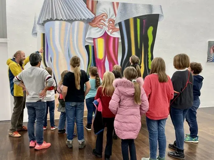 Eine Gruppe Kinder betrachtet ein großformatiges Bild.