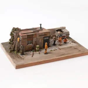 Miniaturszene mit einem kleinen, verwitterten Holzhaus, mehreren Figuren in Winterkleidung und einem alten Auto auf einem rechteckigen Sockel.