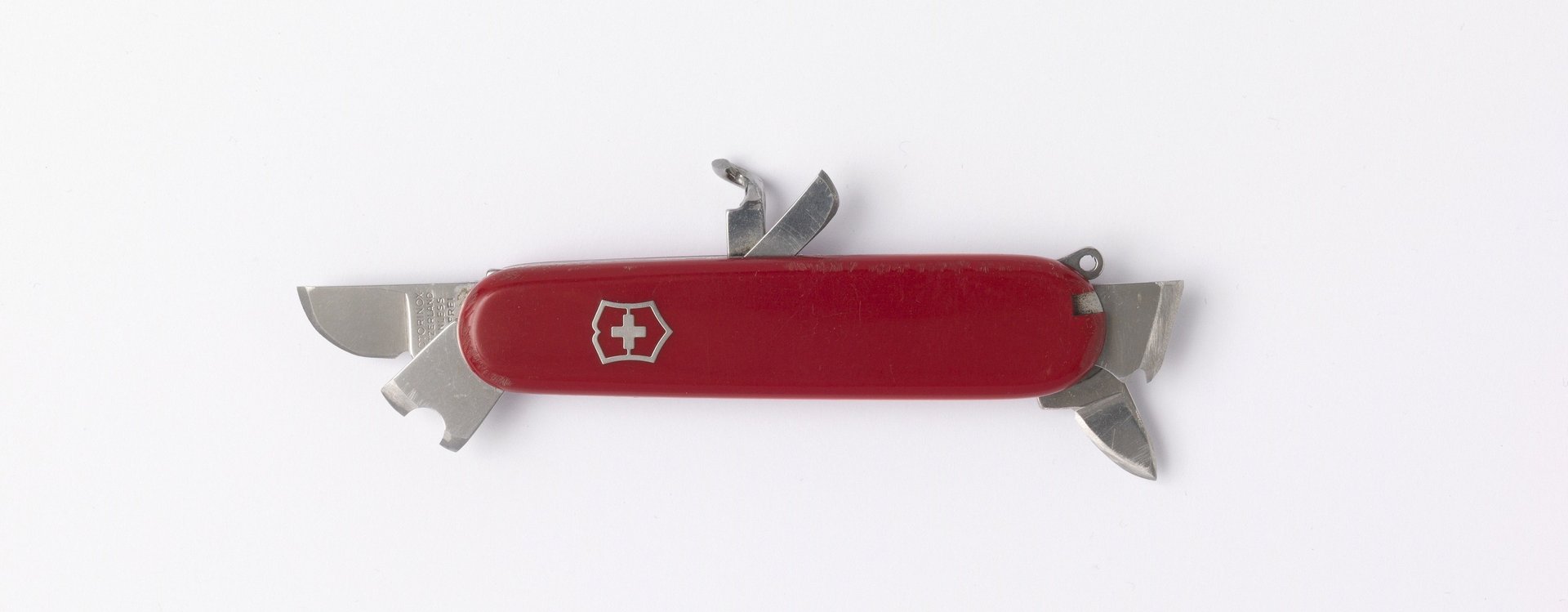 Rotes Schweizer Taschenmesser mit mehreren ausgeklappten Werkzeugen auf weißem Hintergrund
